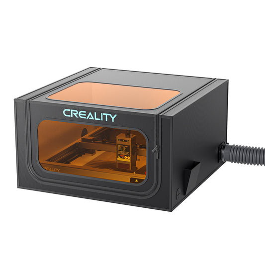 A black rectangular Laser Engraver Enclosure Pro by CrealityFalcon features a transparent amber lid and front panel, revealing the internal components and a connected hose on the right side. The design is both smokeproof and dustproof for added safety and cleanliness. 1000