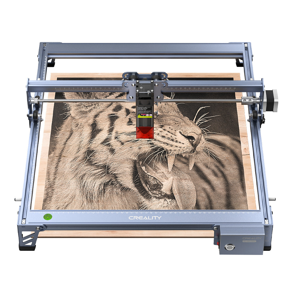 A CR-Laser Falcon 7.5W Laser Engraver is actively etching an image of a roaring tiger on a wooden board. The engraving, partially completed, showcases detailed features of the tiger's face and open mouth. The metallic machine proudly displays the "CREALITY" branding on the front.