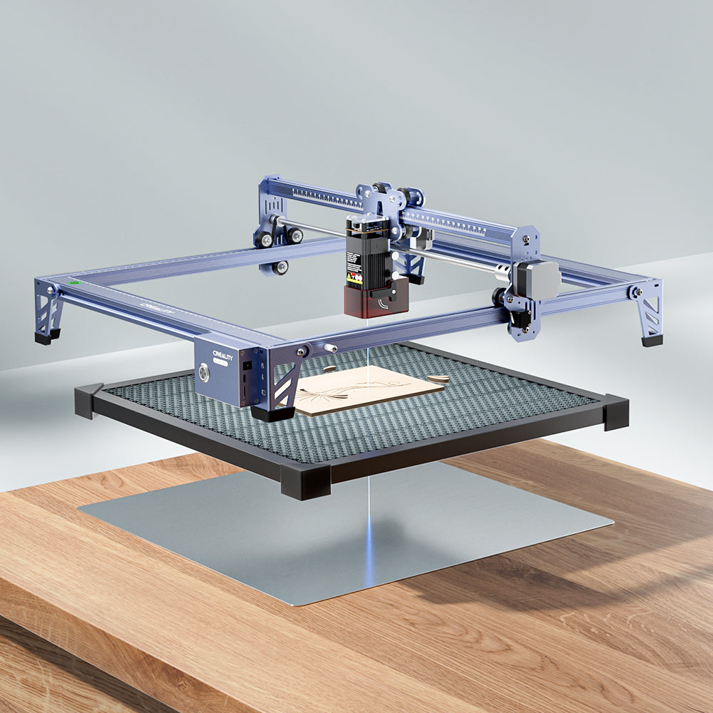 A CR-Laser Falcon 5W laser engraver from CrealityFalcon is seen from above, actively engraving an intricate image of an eagle on a wooden board. The machine features a metallic blue finish with a robust frame, offering ultra-fine engraving accuracy. The eagle design includes the text "5W FALCON" below it.