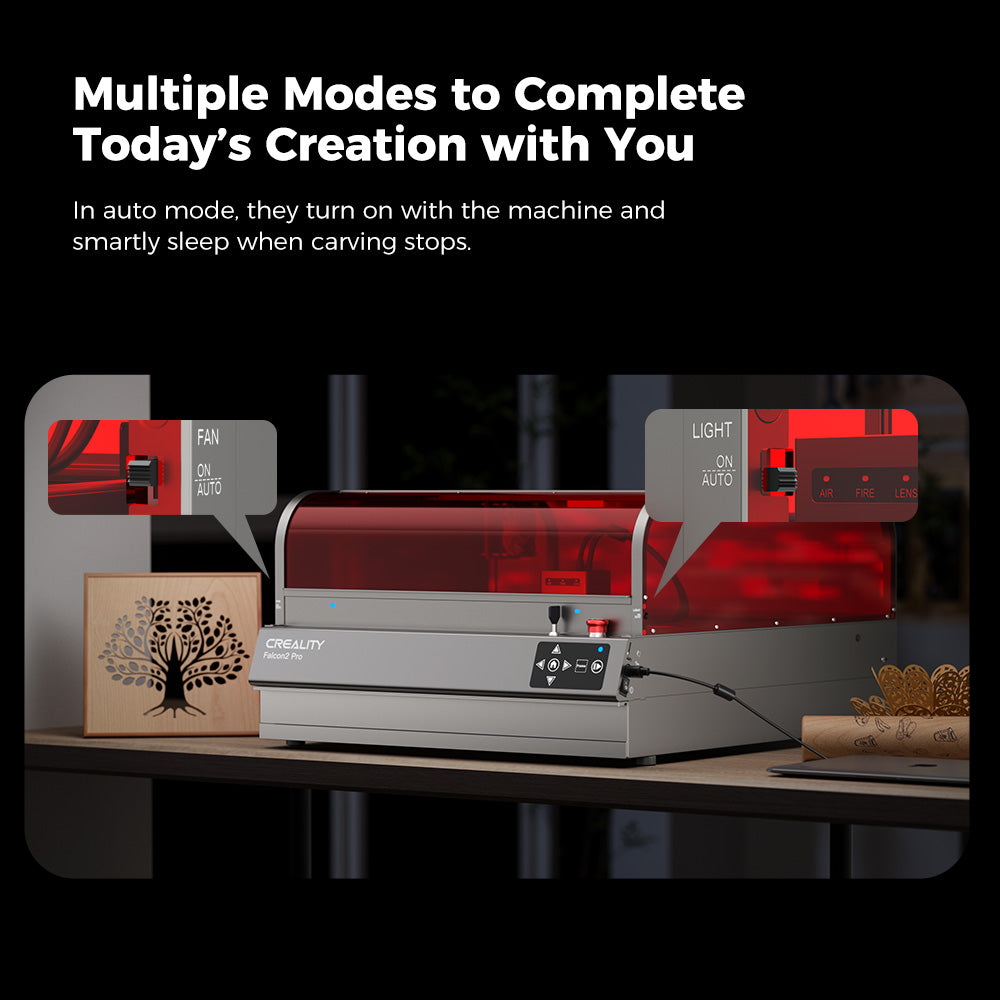 A laser engraving machine with a red protective cover, labeled "CrealityFalcon," is shown on a desk under the text "Multiple Modes to Complete Today's Creation with You." The Falcon2 Pro 22W/40W Enclosed Laser Engraver and Cutter is surrounded by small wooden art pieces and has labels for "FAN" and "LIGHT" with "AUTO" settings. Featuring safety certification, it ensures peace of mind during use.