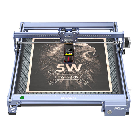 The CR-Laser Falcon 5W Laser Engraver by CrealityFalcon, renowned for its ultra-fine engraving accuracy, etches a detailed image of an eagle with "5W FALCON" text onto a wooden board. The machine features a robust blue metal frame and a control module positioned above the larger engraving area.