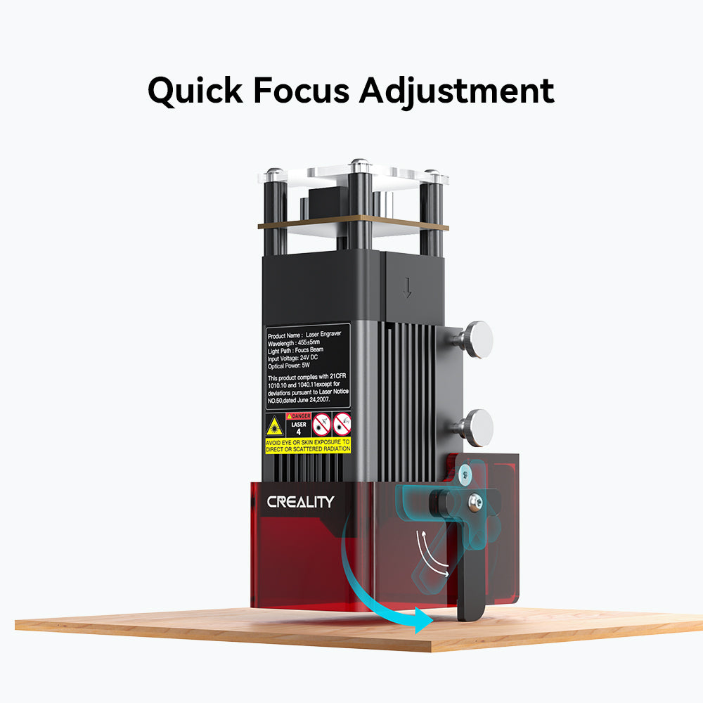 Image of a CrealityFalcon CR-Laser Falcon 5W Laser engraver, often regarded as the best laser engraver, showing a mechanism for quick focus adjustment. The black and red device is mounted on a wooden surface with an arrow indicating the direction to adjust. Clear safety and product labels are visible on the front.