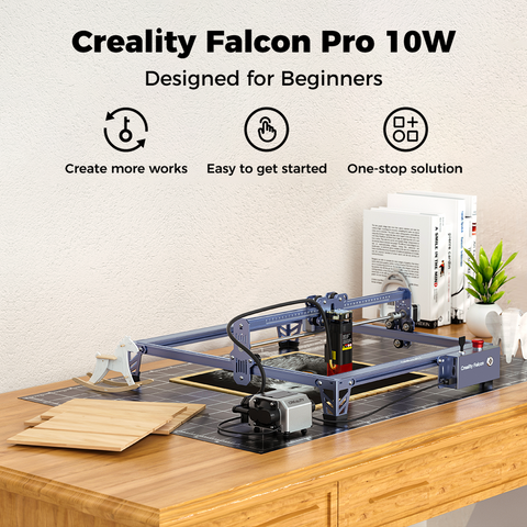 Image of a CrealityFalcon Falcon Pro 10W Laser Engraver on a wooden desk. The CrealityFalcon is set up and ready for use, surrounded by tools, wooden panels, and books. The text on the image highlights that this laser engraver is designed for beginners, easy to start with a one-stop solution.
